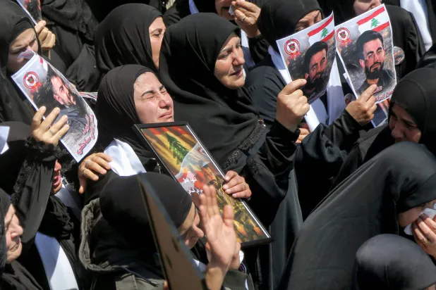 سيدات ينتحبن خلال موكب جنازة ثلاثة من أعضاء الدفاع المدني اللبناني الذين قُتلوا في غارة جوية إسرائيلية على قرية مجدل زون جنوب لبنان (د.ب.أ)