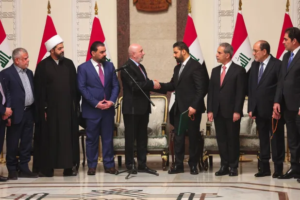 صورة نشرتها الرئاسة العراقية يوم 27 أبريل 2026 تظهر الرئيس العراقي نزار آميدي وهو يصافح رئيس الوزراء المكلف علي الزيدي (أ.ف.ب)