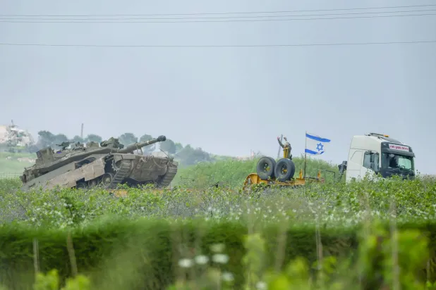An Israeli soldier gestures next to a tank, on the Israeli side of the border with Lebanon, May 3, 2026. REUTERS/Shir Torem