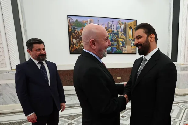 صورة وزعتها الرئاسة العراقية في 27 أبريل 2026 تظهر الرئيس نزار أميدي (وسط) وهو يصافح المكلّف علي الزيدي (يمين) في بغداد