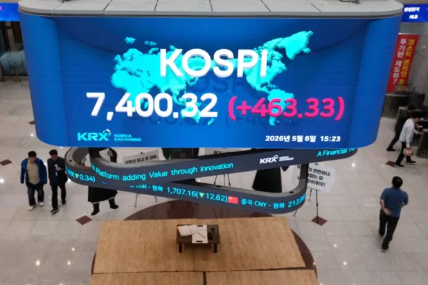 Seul’deki Güney Kore Borsası’nda KOSPI endeksini gösteren ekranın önünden geçen insanlar (AP)