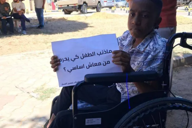 طفل ليبي من ذوي الإعاقة خلال وقفة احتجاجية في طرابلس الأربعاء الماضي (رابطة ضمور العضلات)