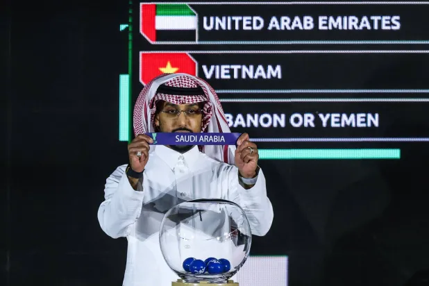 سالم الدوسري قائد الأخضر يعرض ورقة المنتخب السعودي خلال القرعة (أ.ف.ب)