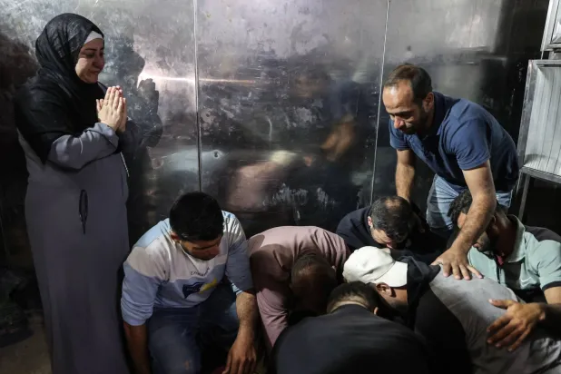 فلسطينيون يبكون ذويهم الذين قُتلوا خلال غارات إسرائيلية في مستشفى الشفاء بمدينة غزة (أ.ف.ب)