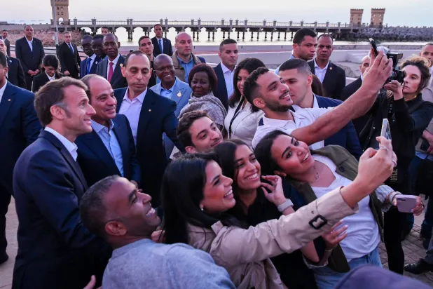 السيسي وماكرون خلال التقاط مواطنين مصريين لصور بكاميرات هواتفهم المحمولة في الإسكندرية السبت (الرئاسة المصرية)