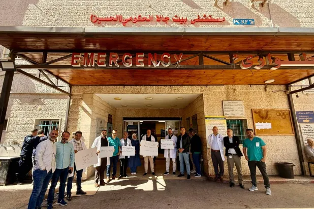 أطباء فلسطينيون في وقفة احتجاجية أمام مستشفى بيت جالا الحكومي في الضفة الغربية يوم الأحد (الشرق الأوسط)