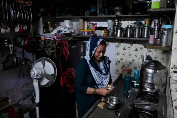 Rakhi Gulshan Singh, a seamstress and policyholder of a heat insurance scheme, preparing a meal inside her single-room rented home in Ahmedabad. Shammi MEHRA / AFP
