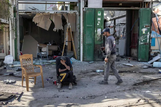 Palestinian workers rest during the demolition of shops before the arrival of an Israeli army demolition team in the occupied Palestinian West Bank town of Al-Eizariya adjacent to East Jerusalem on Sunday (AFP) 