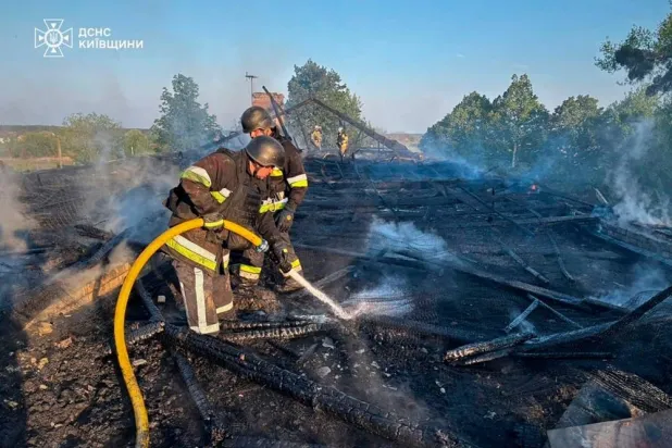  In this photo provided by the Ukrainian Emergency Service, emergency services personnel work to extinguish a fire following a Russian drone attack in Kyiv region, Ukraine, Tuesday, May 12, 2026. (Ukrainian Emergency Service via AP) 