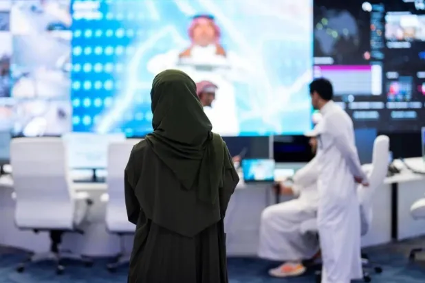 امرأة تقف أمام شاشة معلومات في معرض «ليب» التقني بالسعودية (واس)