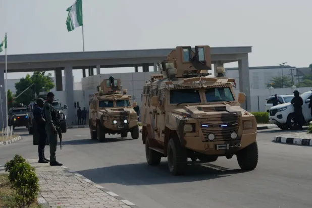 ضباط من الشرطة والجيش النيجيريَّين يصلون لحضور فاعلية في مدينة مينا النيجيرية في 22 ديسمبر 2025 (أ.ب)