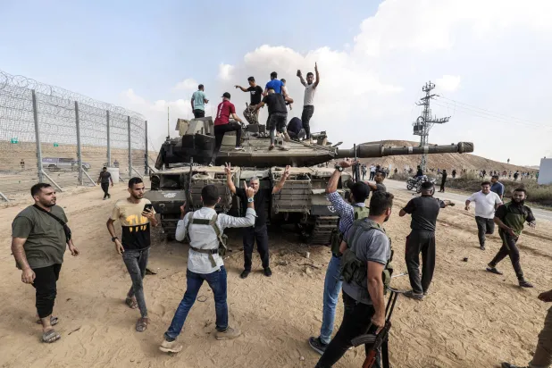 FILED - 07 October 2023, Palestinian Territories, Khan Yunis: Palestinians take control of an Israeli tank after crossing the border fence with Israel from Khan Yunis. Photo: Abed Rahim Khatib/dpa