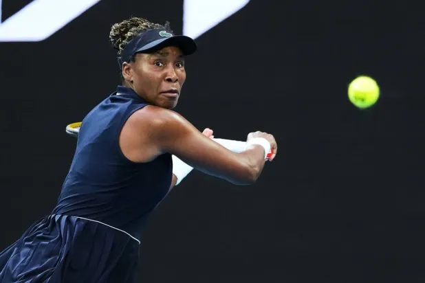 Venus Williams, of the United States, plays a backhand return to Olga Danilovic, of Serbia, during their first round match at the Australian Open tennis championship in Melbourne, Australia, Jan. 18, 2026. (AP)