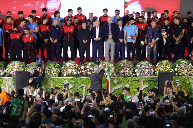 لاعبو المنتخب الإيراني على منصة التتويج خلال حفل وداع أقيم في طهران (إ.ب.أ)