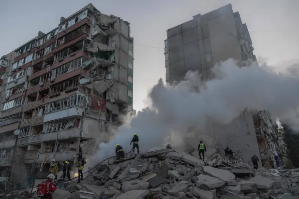 Rescuers work at a residential building partially destroyed following Russian drone and missile strikes in Kyiv on May 14, 2026, amid the Russian invasion in Ukraine. (Photo by Roman PILIPEY / AFP)
