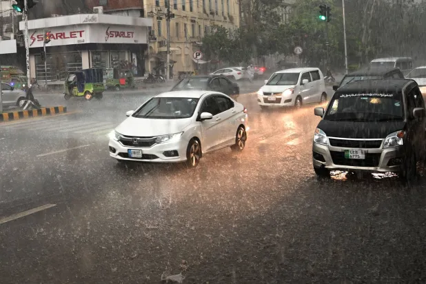Vehicles drive on a road during heavy rain in Lahore, Pakistan, 13 May 2026. EPA/A. HUSSAIN