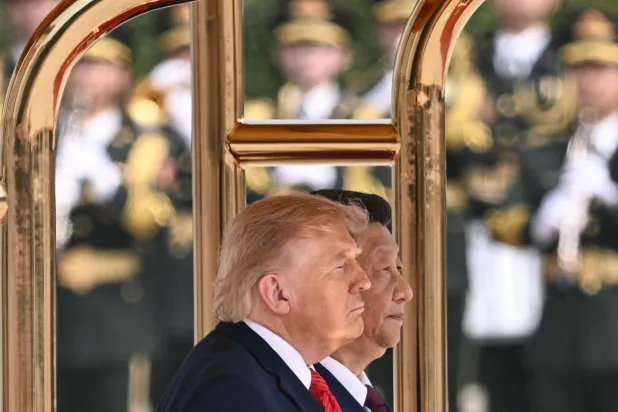 الرئيس الأميركي دونالد ترامب ونظيره الصيني شي جينبينغ يقفان أثناء عزف النشيدين الوطنيين لبلديهما خلال حفل استقبال في قاعة الشعب الكبرى في بكين (أ.ف.ب)