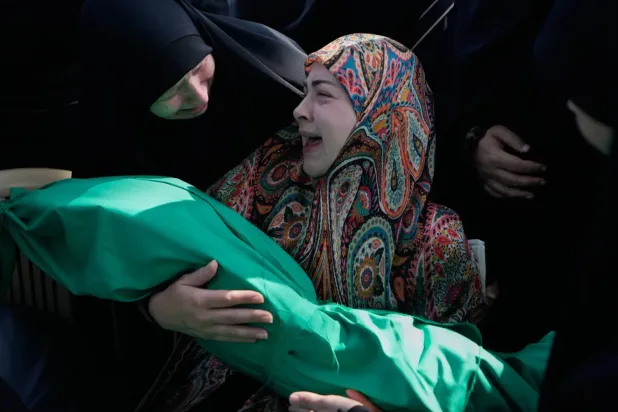 Es-Saksakiye kasabasına düzenlenen İsrail saldırısında hayatını kaybeden 6 aylık bebek Meryem Fahs’ın cenazesini taşıyan bir kadın (AP)