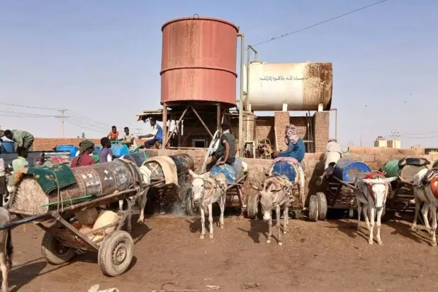 Water sellers gather with donkey-drawn carts to collect and sell water. (Asharq Al-Awsat)