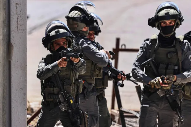  A member of the Israeli security forces aims his weapon while patrolling during a military raid in the Qalandia refugee camp, south of Ramallah in the Israeli-occupied West Bank, on May 11, 2026. (AFP)