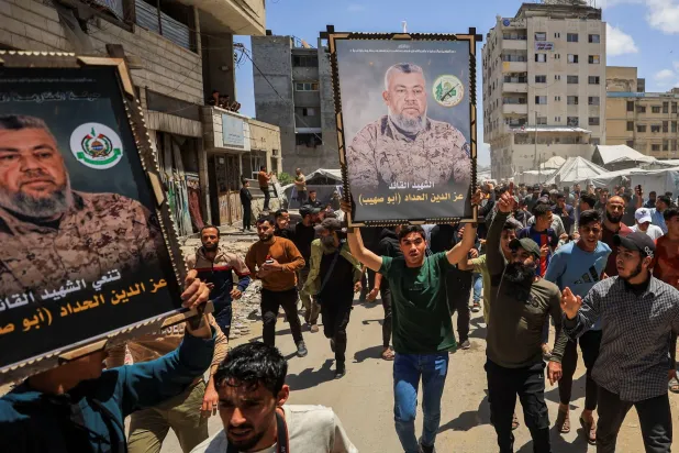 فلسطينيون يحملون صورة كبيرة للقائد عز الدين الحداد خلال تشييعه في مدينة غزة يوم السبت (رويترز)