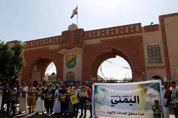 حوثيون أمام بوابة جامعة صنعاء يرفعون صور زعيمهم وزعيم «حزب الله» اللبناني الأسبق نصر الله (أرشيفية - أ.ف.ب)
