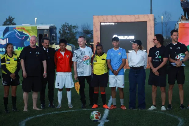 لاري مولين جونيور من فرقة «يو تو» مع لاعبي إندونيسيا والأرجنتين (رويترز)