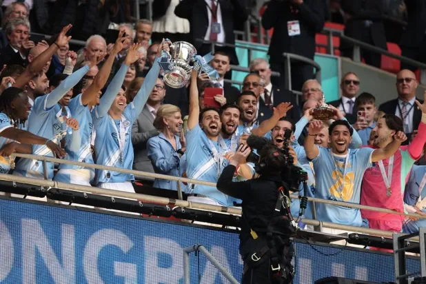  Manchester City players celebrate with the winner's trophy after the English FA Cup final soccer match between Chelsea and Manchester City in London, Saturday, May 16, 2026. (AP) 