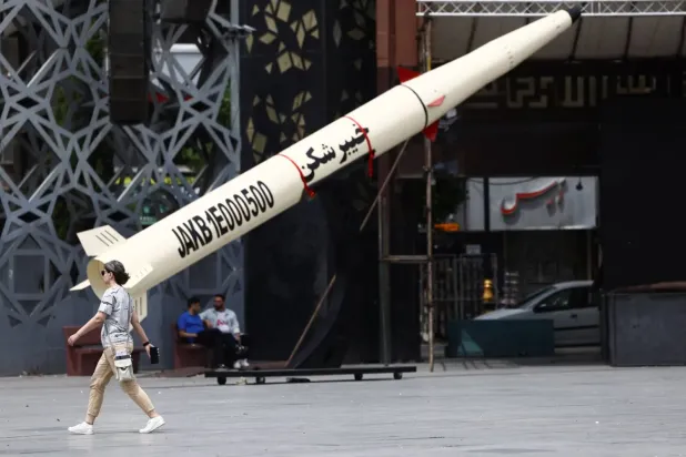 Tahran’da Hayber model balistik füze maketinin yanından geçen İranlı bir kadın (Reuters)