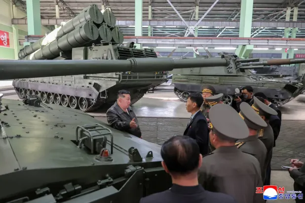 Kim Jong Un, yeri açıklanmayan bir mühimmat fabrikasını ziyaret ederken (AFP)