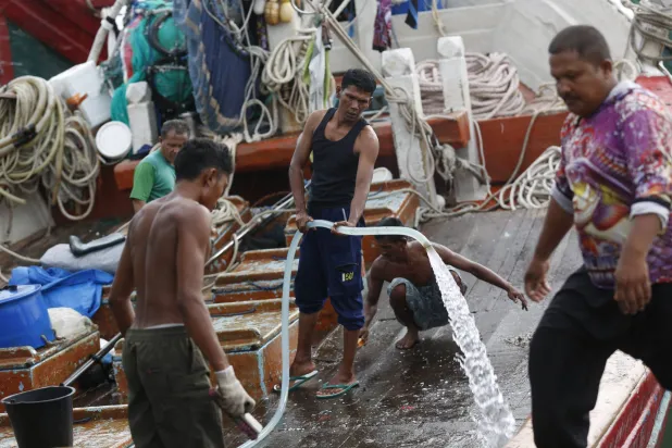 صيادون ينظفون قاربهم بعد عودتهم من البحر في ميناء لامبولو للصيد التقليدي في باندا آتشيه، إندونيسيا (إ.ب.أ)