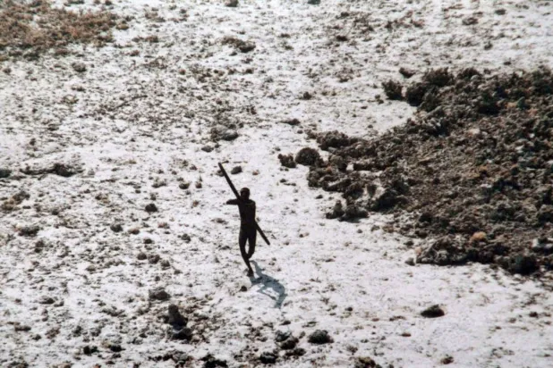 File photo of a man with the Sentinelese tribe aiming his bow and arrow at an Indian Coast Guard helicopter as it flies over North Sentinel Island in the Andaman Islands. Handout / Indian Coast Guard/AFP/File
