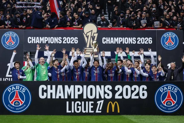  PSG players and Paris Saint-Germain's Spanish head coach Luis Enrique (R) celebrate with the French Ligue 1 trophy after winning the championship ahead of the French L1 football match between Paris FC and Paris Saint-Germain (PSG) at the Stade Jean-Bouin in Paris on May 17, 2026. (AFP) 