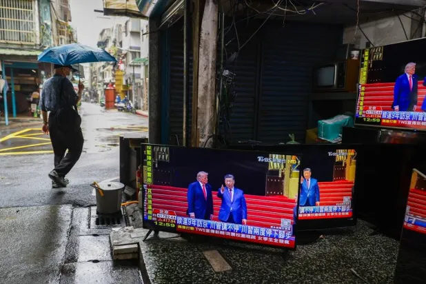 A pedestrian walks past a secondhand and TV repair store, with TV screens broadcasting the Beijing meeting between US President Donald Trump and Chinese President Xi Jinping, in Taipei, Taiwan, 14 May 2026. (EPA)