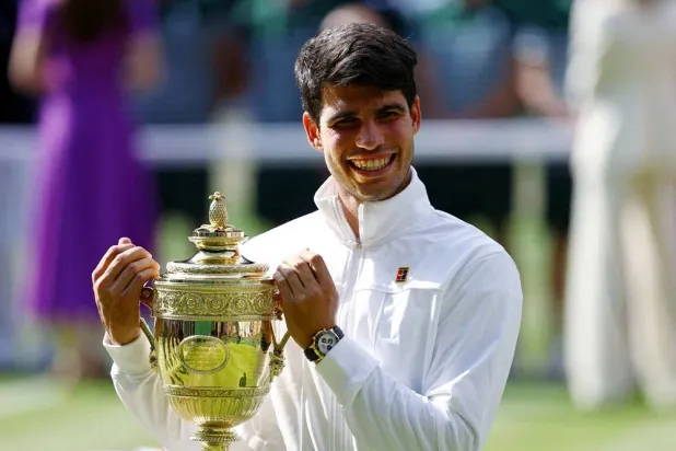 Tennis - Wimbledon - All England Lawn Tennis and Croquet Club, London, Britain - July 14, 2024 Spain's Carlos Alcaraz poses for a picture with the trophy after winning his men's singles final against Serbia's Novak Djokovic. (Reuters)