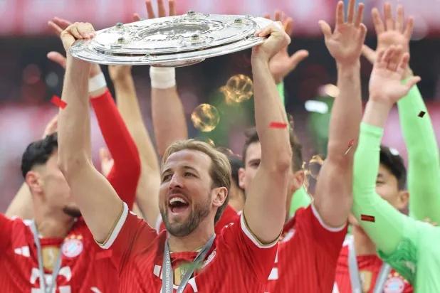 Bayern Munich's English forward #09 Harry Kane raises celebrates and raises the Bundesliga trophy after winning the German first division Bundesliga football match between FC Bayern Munich and FC Cologne in Munich, southern Germany, on May 16, 2026. (AFP)