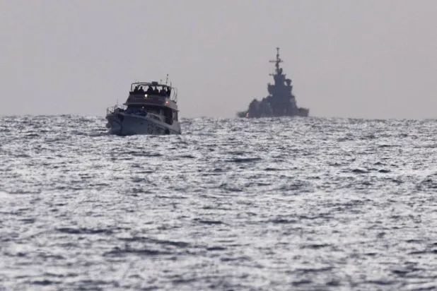  Israeli soldiers are seen on a vessel bearing symbols of the Global Sumud Flotilla, with an Israeli military ship behind it, as seen from Ashdod, southern Israel, May 19, 2026. (Reuters)