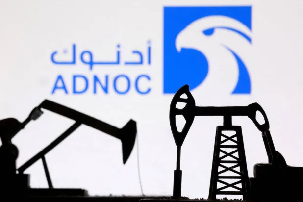 رافعات مضخات نفط مطبوعة بتقنية الطباعة ثلاثية الأبعاد بالإضافة إلى شعار «أدنوك» (رويترز)