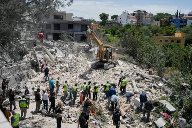 Dün Güney Lübnan'daki Deyru'l-Kanun en-Nehr köyünde İsrail’in düzenlediği saldırıda yerle bir olan bir evin enkazında kurtarma ekipleri tarafından yürütülen arama çalışmaları (AP)
