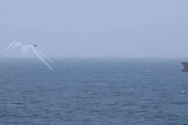 ABD Merkez Komutanlığı'nın salı günü X platformunda yayınladığı videodan alınan karede, bir helikopterin İran'a ait tankeri rota değiştirmeye zorladığı görülüyor. (CENTCOM)