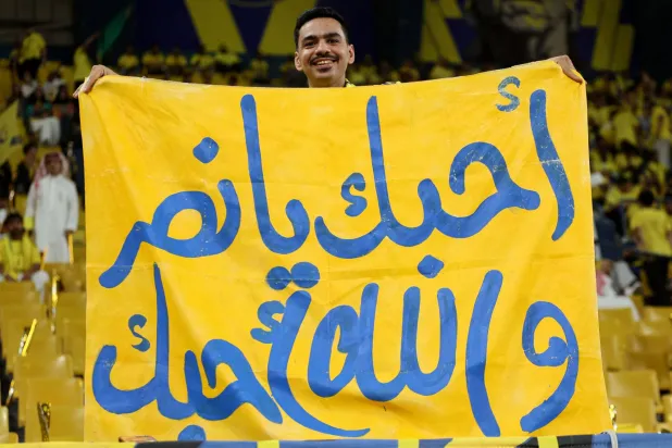 مشجع نصراوي يساند فريقه خلال المباراة أمام ضمك (أ.ف.ب)