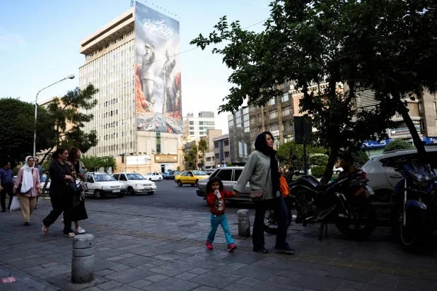 FILE PHOTO: People walk past a billboard about the Strait of Hormuz, in Tehran, Iran, May 17, 2026. Majid Asgaripour/WANA (West Asia News Agency) via REUTERS 