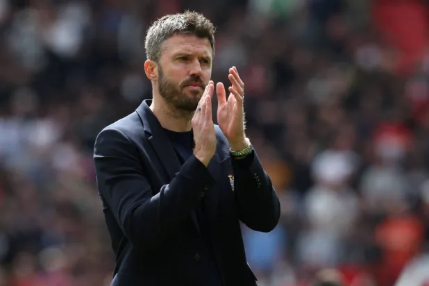 (FILES) Manchester United's English interim head coach Michael Carrick applauds fans on the pitch after their final home appearance in the English Premier League football match between Manchester United and Nottingham Forest at Old Trafford in Manchester, north west England, on May 17, 2026. (Photo by Darren Staples / AFP) 