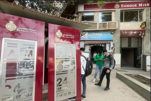 مواطنون مصريون أمام ماكينات الصرف التابعة لأحد البنوك الحكومية (رويترز)