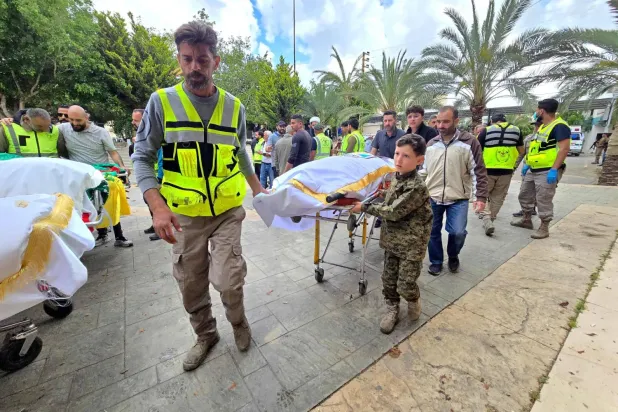 İsrail'in güneydeki Deyr Kanun en-Nehr beldesine düzenlediği baskında hayatını kaybedenlerin cenazeleri, Lübnan'ın güneyindeki Sur bölgesine defin törenleri için getirildi (AFP)