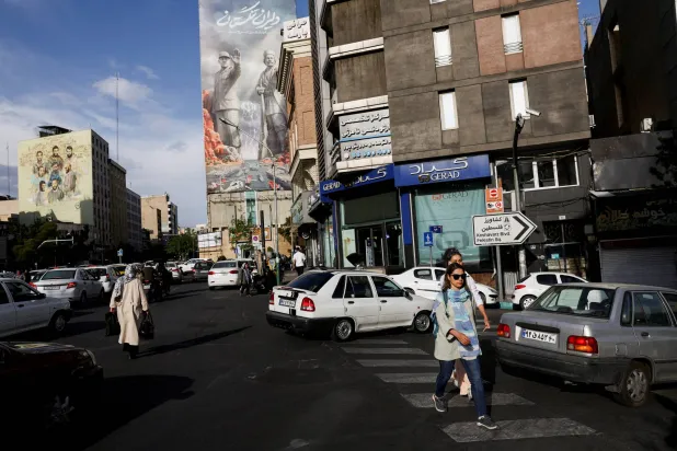 FILE PHOTO: People walk past a billboard about the Strait of Hormuz, in Tehran, Iran, May 17, 2026. Majid Asgaripour/WANA (West Asia News Agency) via REUTERS