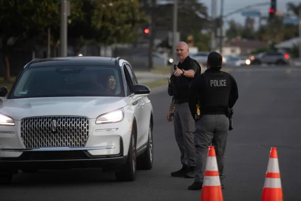 Garden Grove police direct evacuees towards a shelter after a chemical leak from a large storage tank threatened residents in Garden Grove, California on May 22, 2026. (Photo by Blake Fagan / AFP)