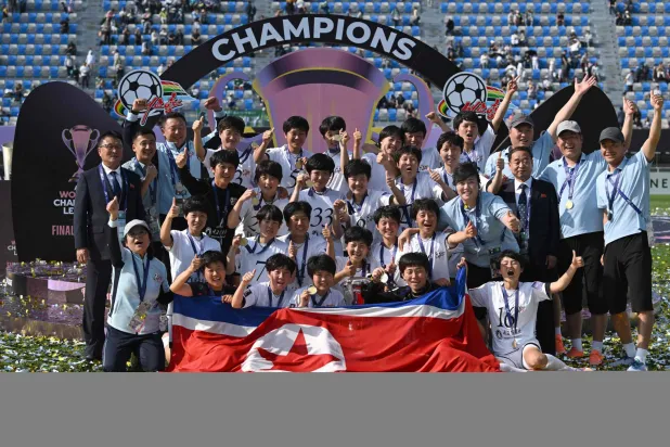 Naegohyang Women's FC players celebrate with the trophy during the victory ceremony after the AFC Women's Champions League final football match between North Korea's Naegohyang Women's FC and Japan's Tokyo Verdy Beleza in Suwon on May 23, 2026. (Photo by Jung Yeon-je / AFP)