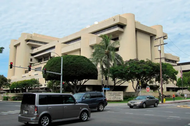 FILE - Cars pass in front of the federal building housing the US District Court in Honolulu on March 7, 2014. (AP Photo/Jennifer Sinco Kelleher, File)