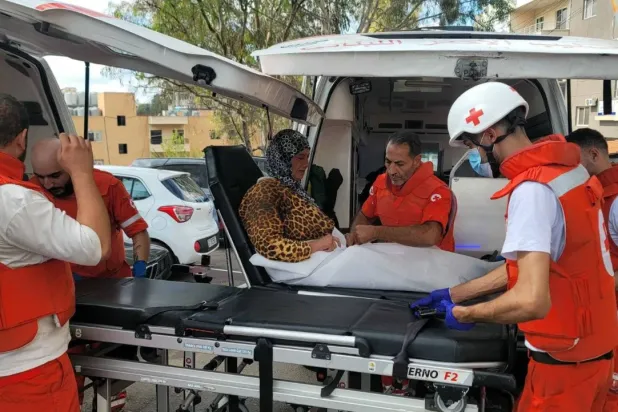 Volunteers from the Lebanese Red Cross rescue a woman in the city of Nabatieh in South Lebanon (AFP)
